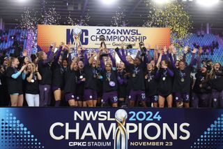 Orlando Pride players celebrate with the winner's trophy after defeating the Washington Spirit 1-0 in the NWSL 2024 Championship Game at CPKC Stadium on November 23, 2024 in Kansas City, Missouri.