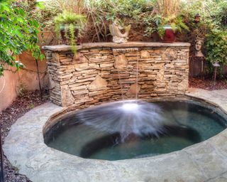 sunken hot tub with waterfall
