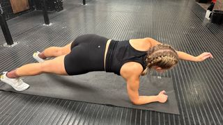 Woman doing plank forward reach exercise