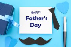 Happy Father's Day card against a blue background. With a black tie and moustache beside the card. 