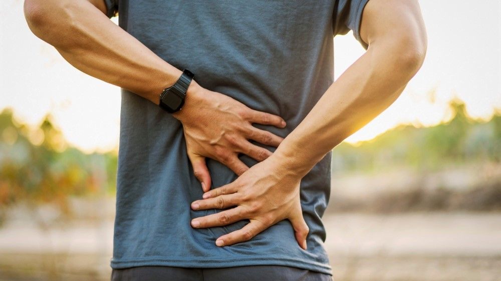 a photo of a man holding his back 