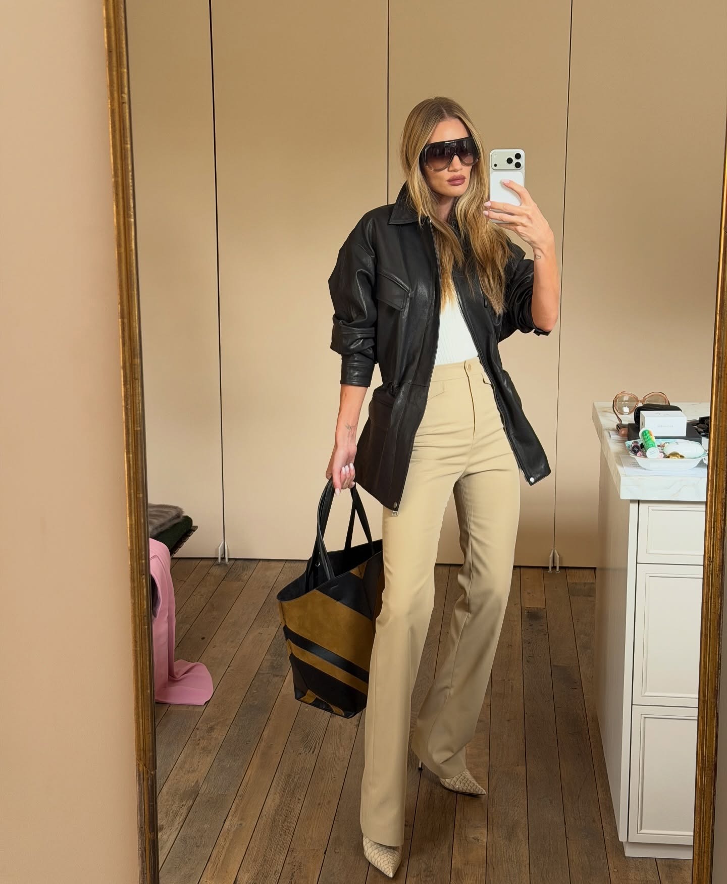 Elsa Hosk wearing a leather peplem jacket and khaki pants