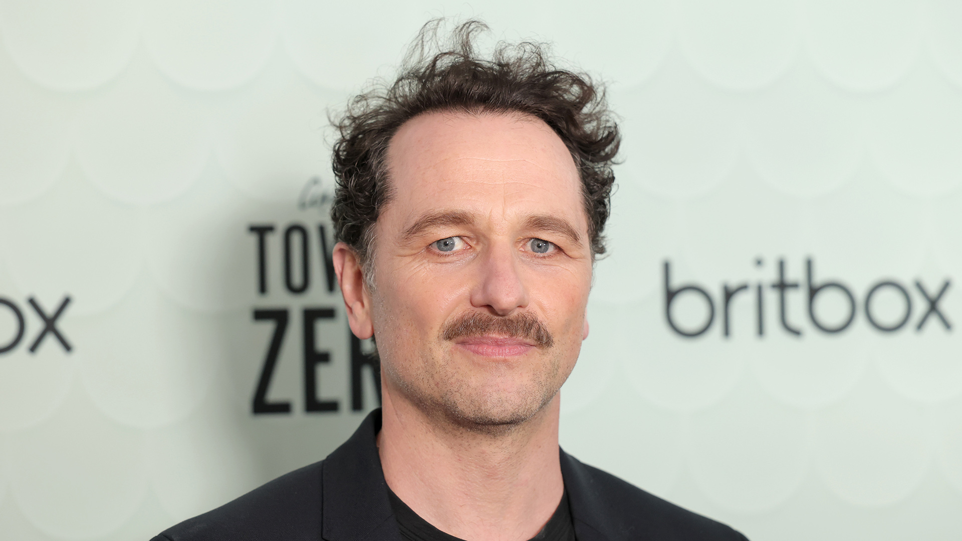 Matthew Rhys posing for photographs at an event for Britbox's Towards Zero