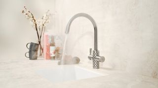 Boiling water tap running in a sink with steam