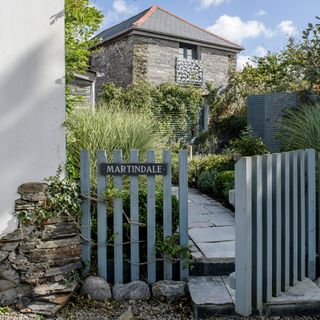 grey house plants and blue gate with name plate