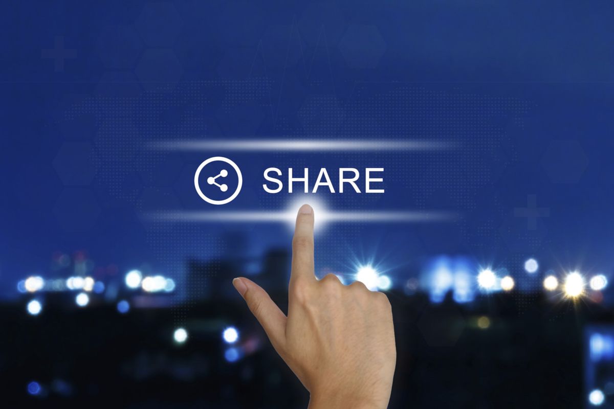 Hand pushing share button on touch screen 