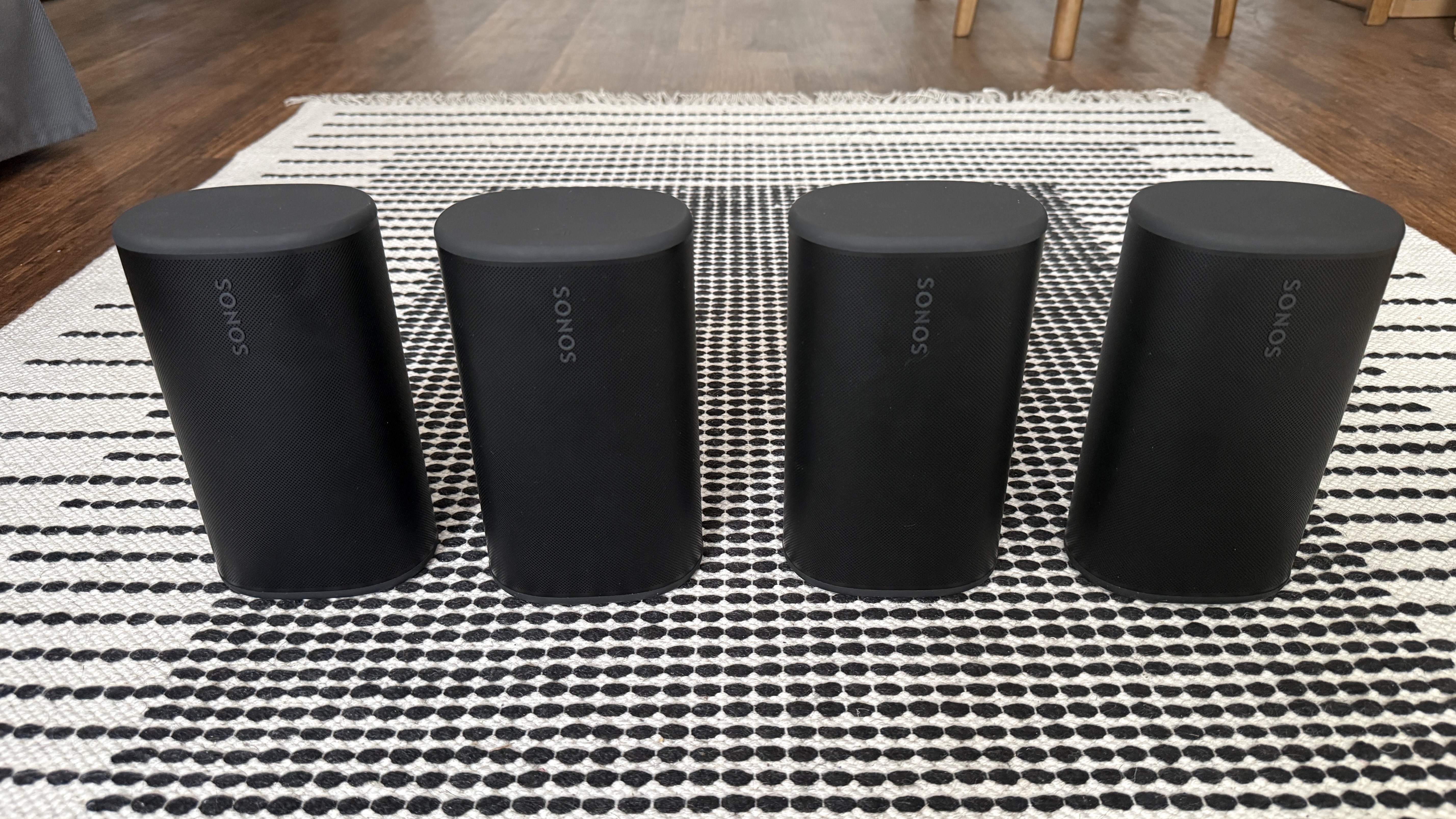 Four Sonos Play speakers on a stripey rug