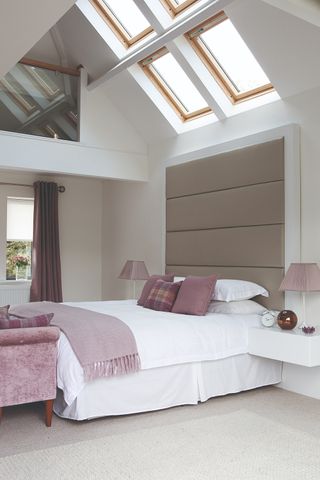 A bedroom in a garage conversion with a double bed and skylights
