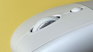 The Logitech Lift for Mac mouse against a yellow background.