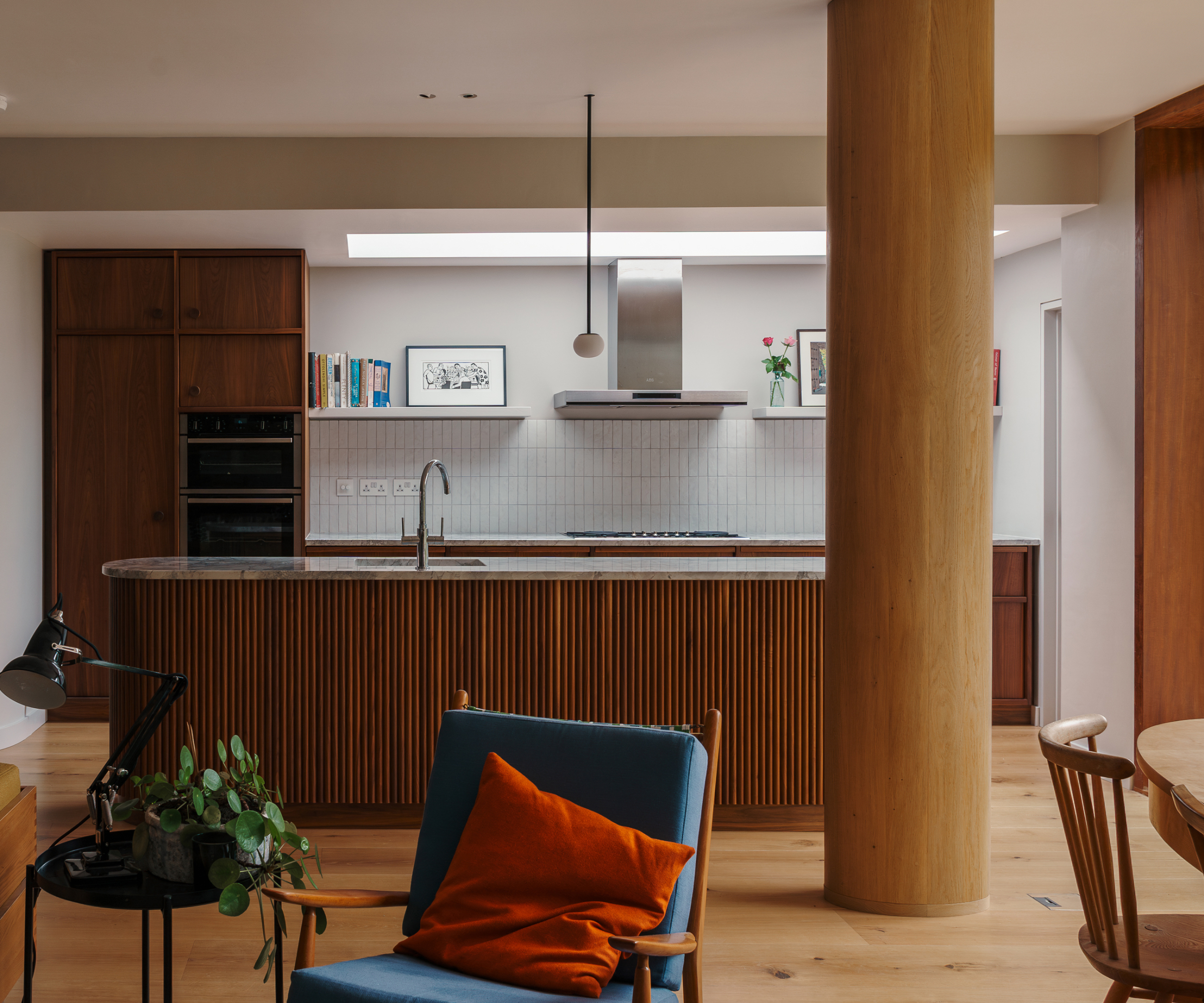 kitchen with wooden floor, wooden column and fluted wood kitchen island and cabinets