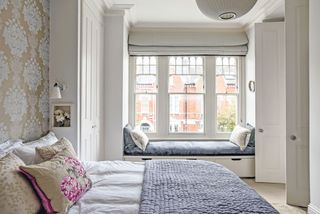 light and large master bedrom with feature wall and window seat photographed by polly eltes