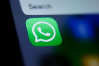 A close up of a WhatsApp logo on a phone screen