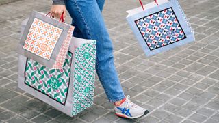 Cropped shot of a women carrying three patterned bags