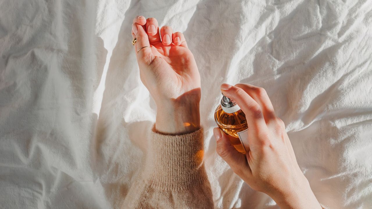 A woman spray perfume onto her wrist