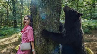 (L to R) Keri Russell as Sari, hiding from, the bear in Cocaine Bear