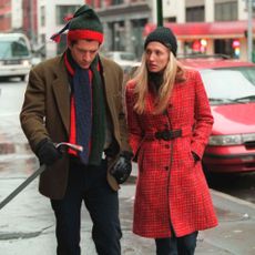 Carolyn Bessette Kennedy wears a red Prada coat