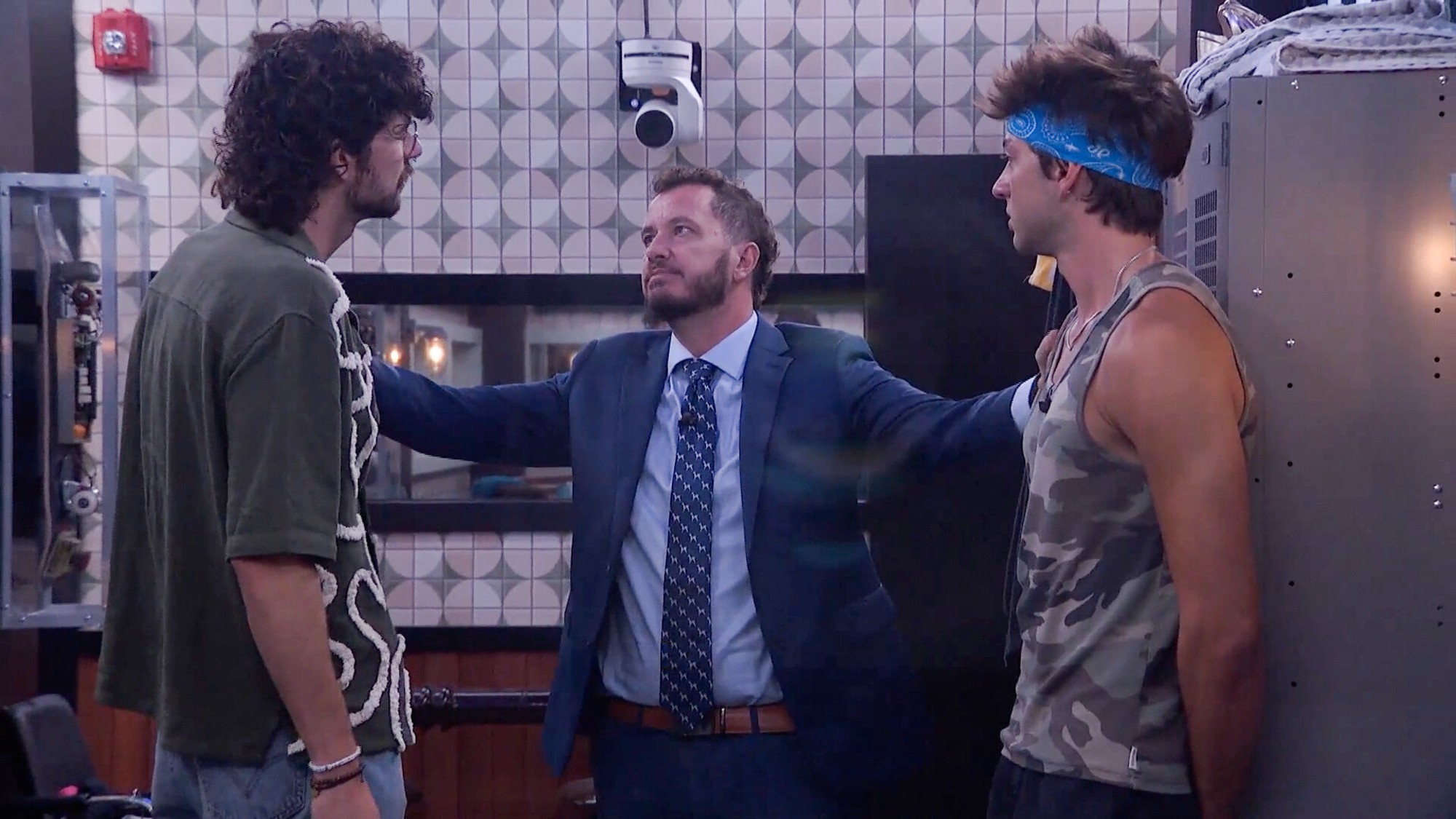Barrett and Drew listen to Rick Devens as he puts his arms on both of them. 