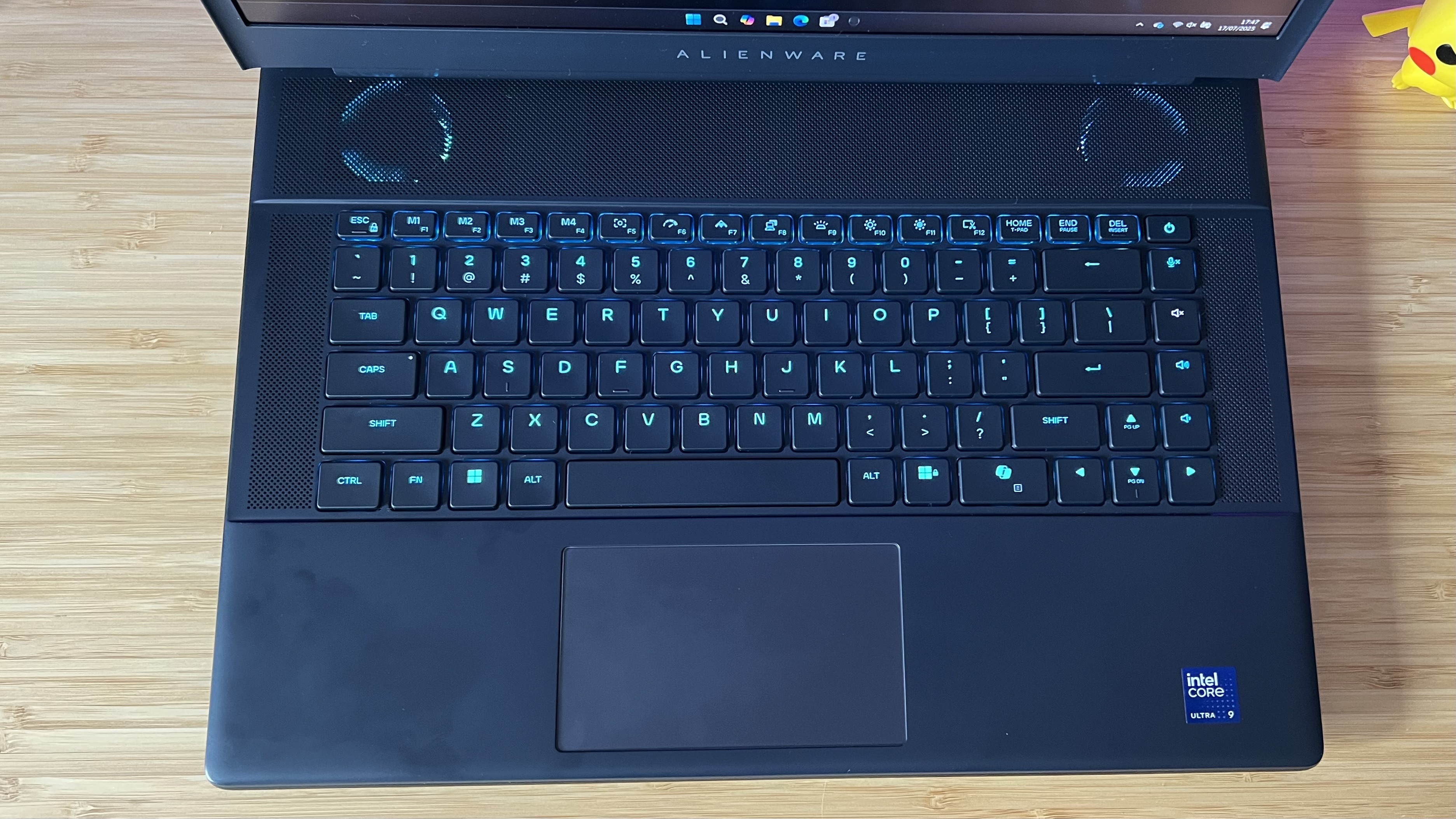 Top down view of Alienware 16 Area-51 gaming laptop keyboard and trackpad on a wooden desk