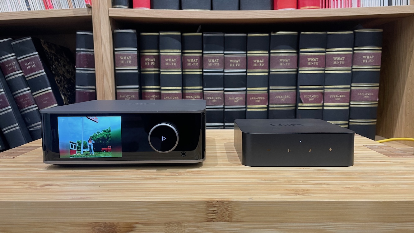 The WiiM Ultra and WiiM Pro Plus next to each other on a wooden surface.