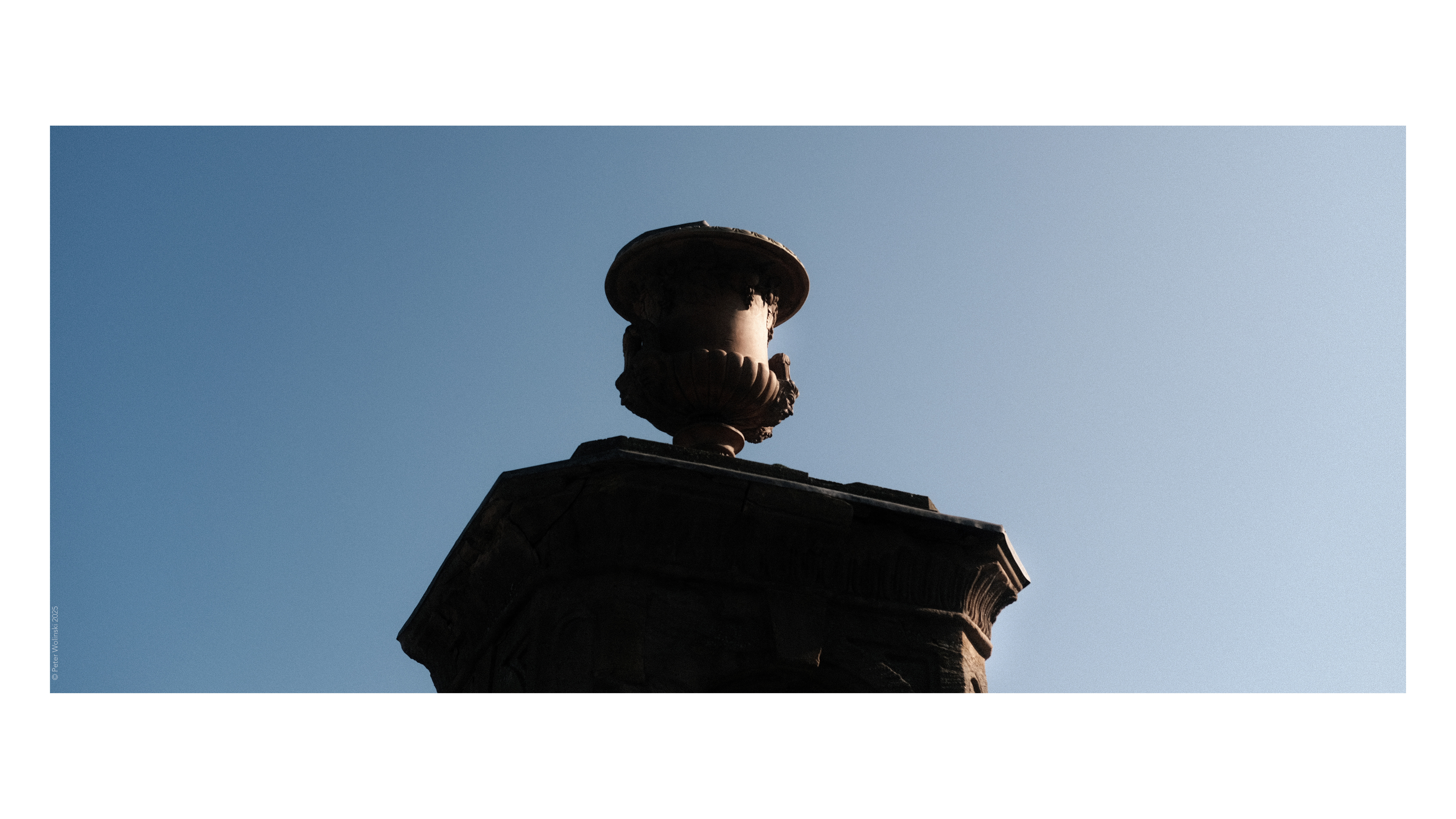 A photo of a large stone monument against a blue sky, shot on the Fujifilm X-E4