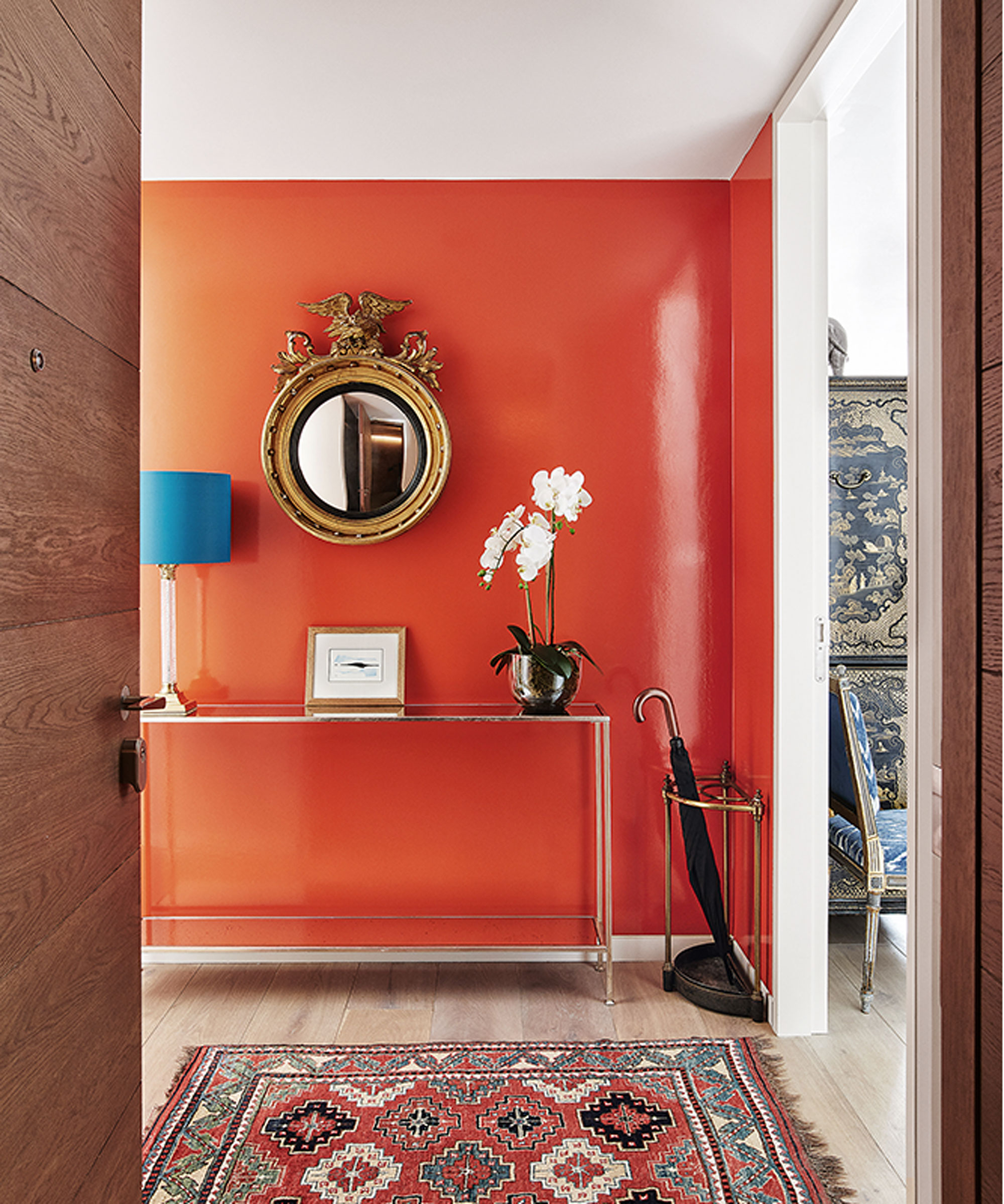 red hallway with metal console table and gilt mirror