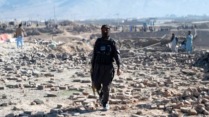 A Taliban security official walks through rubble after an air strike by Pakistan on the outskirts of Kabul earlier this month
