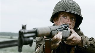 Richard Winters points his rifle at someone off screen in Band of Brothers