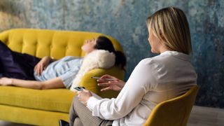 a woman lies on a couch in a therapist's office