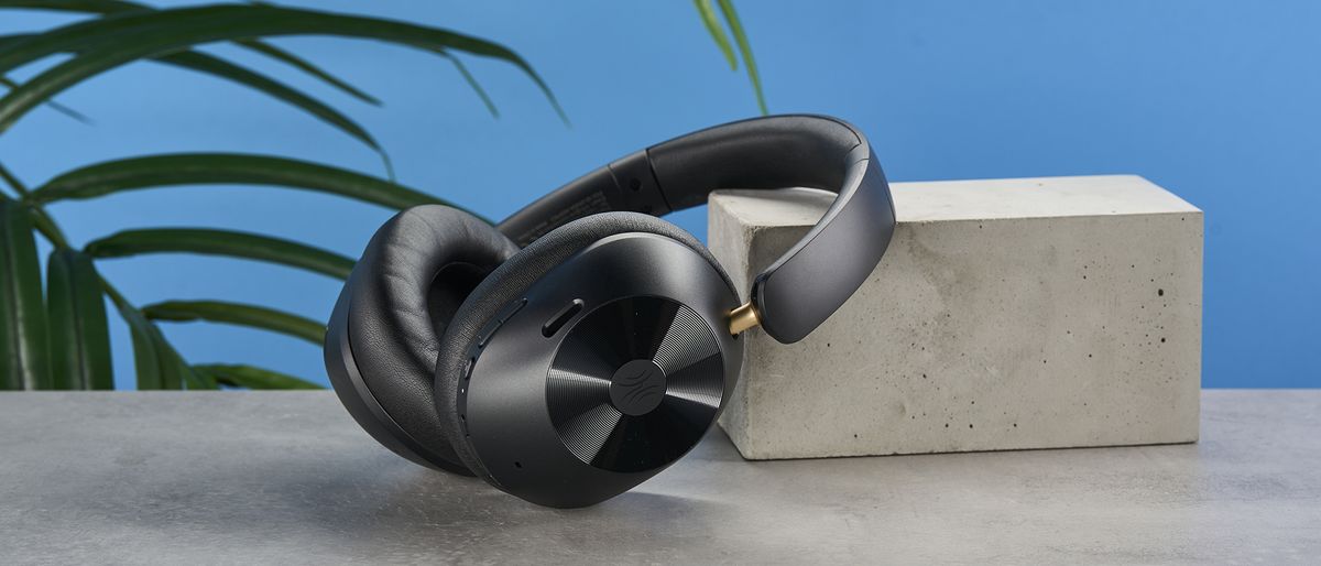 a pair of black bluetooth headphones made by OneOdio Focus A5 is photographed against a blue background