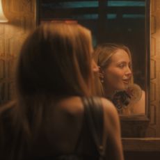 iris apatow as amanda and christina missal as bree speaking in a bar bathroom with their reflections in a mirror in a still from tell me lies season 3 premiere