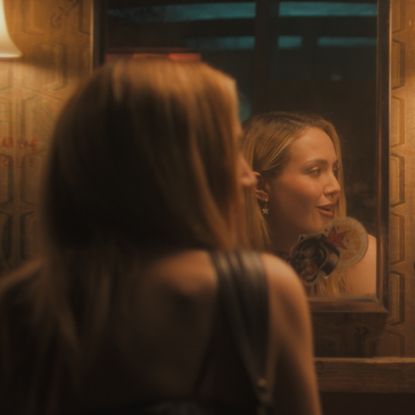 iris apatow as amanda and christina missal as bree speaking in a bar bathroom with their reflections in a mirror in a still from tell me lies season 3 premiere