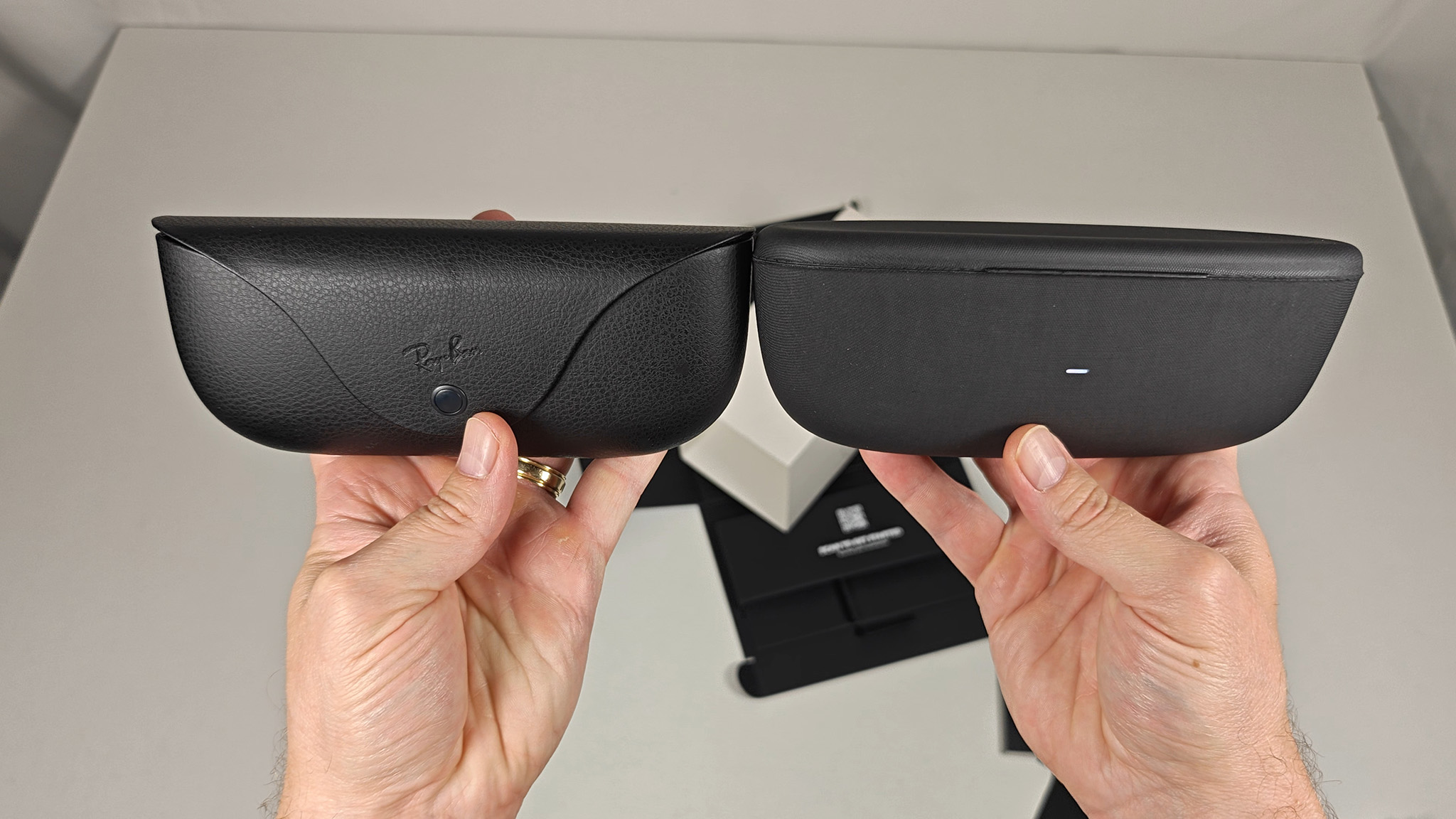 Comparing the size and shape of Ray-Ban Meta Smart Glasses and Oakley Meta HSTN's charging cases