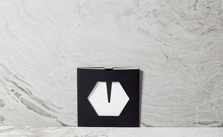 A die-cut, black outer pocket was laser-cut with a hollow hexagon shape that was also sliced into the invitation’s stark white interior card