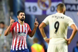 Real Madrid's Karim Benzema stands with his hands on his hips as Atletico Madrid striker Diego Costa celebrates a goal in the teams' UEFA Super Cup clash in August 2018.