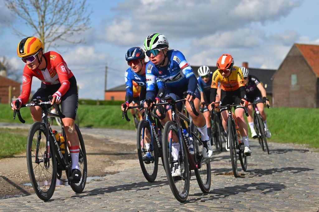 WAREGEM BELGIUM MARCH 27 LR Rebecca Koerner of Denmark and Team UnoX Mobility and Justine Ghekiere of Belgium and Team AG InsuranceSoudal compete passing through a Varentstraat cobblestones sector during the 12nd Dwars door Vlaanderen 2024 Womens Elite a 1299km one day race from Waregem to Waregem on March 27 2024 in Waregem Belgium Photo by Luc ClaessenGetty Images
