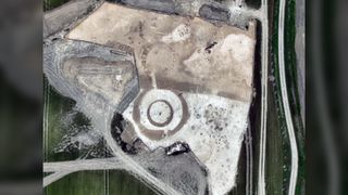 A bird's-eye view of the site, which is white and brown and shows a bull's-eye like barrow burial.