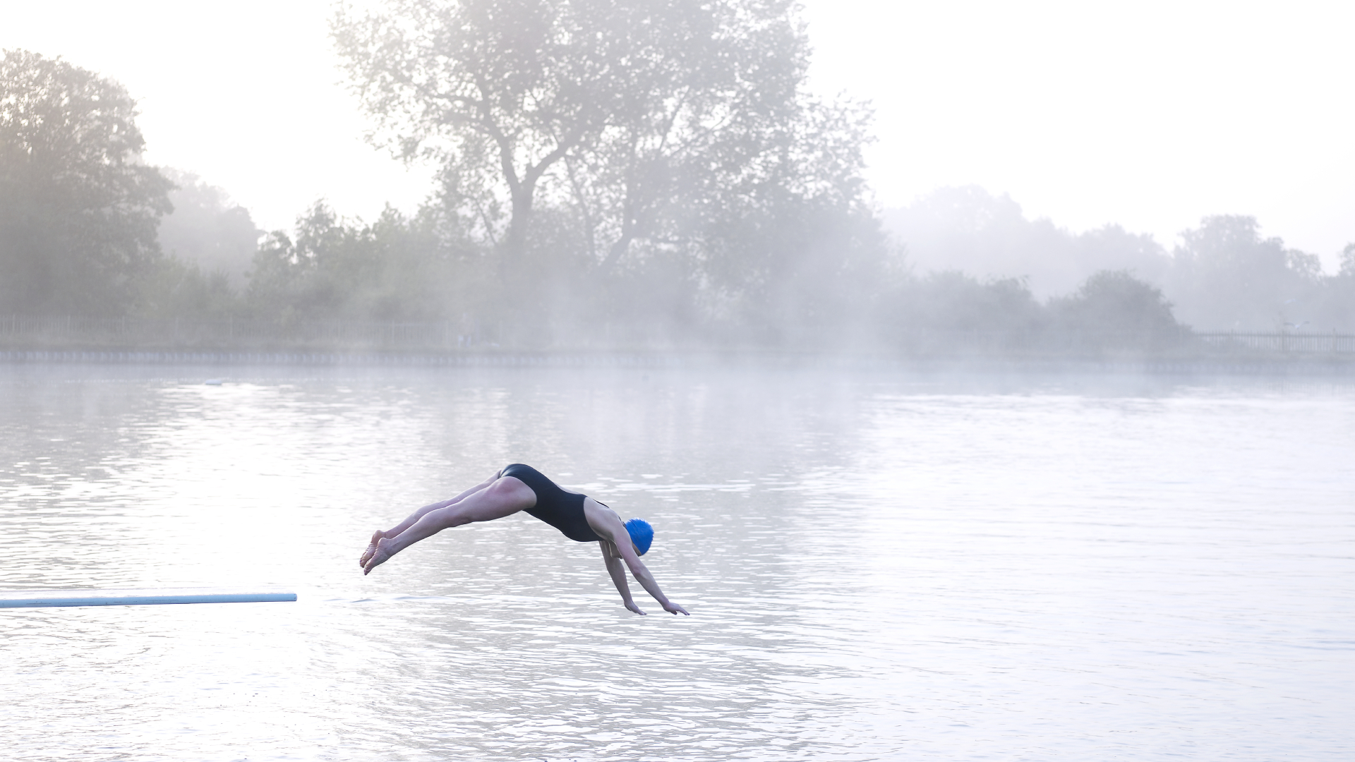 woman diving into cold water lake