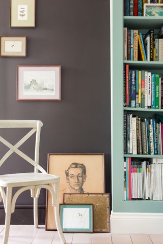 A dark brown wall with light blue bookcase