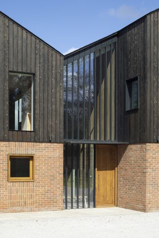 stained timber cladding with brick on self build