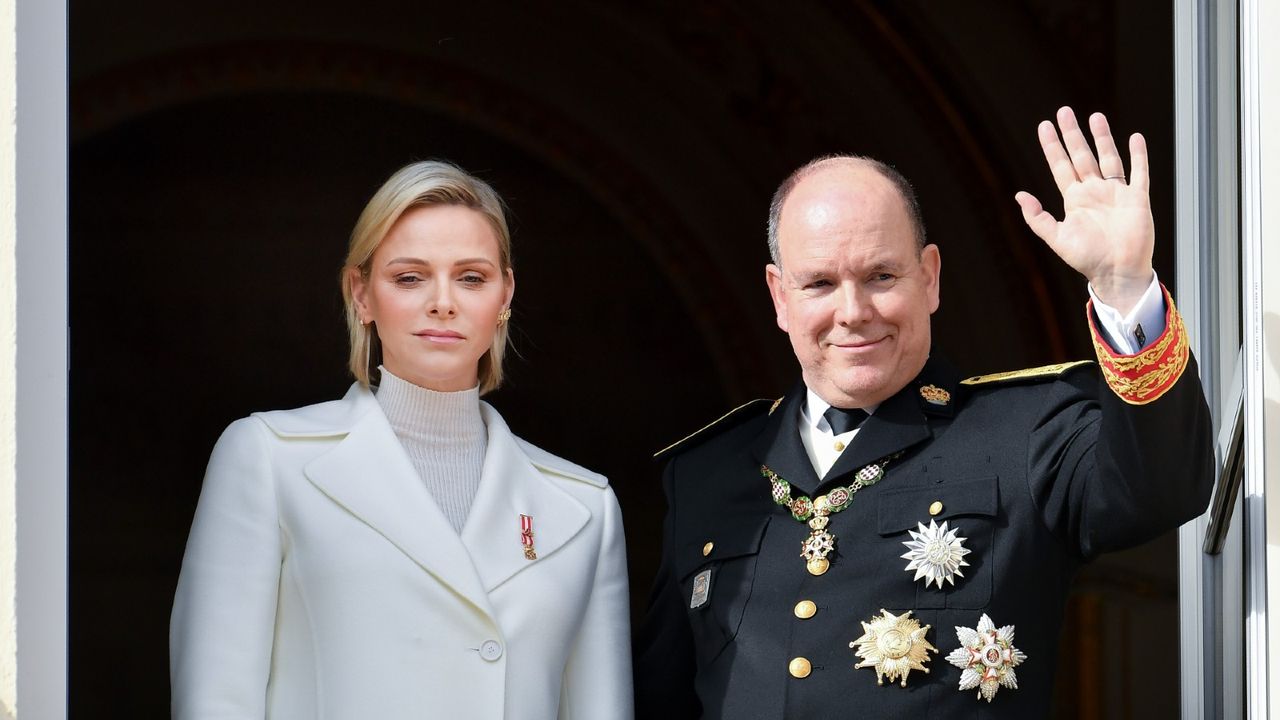 Princess Charlene of Monaco and Prince Albert of Monaco waving at a crowd.