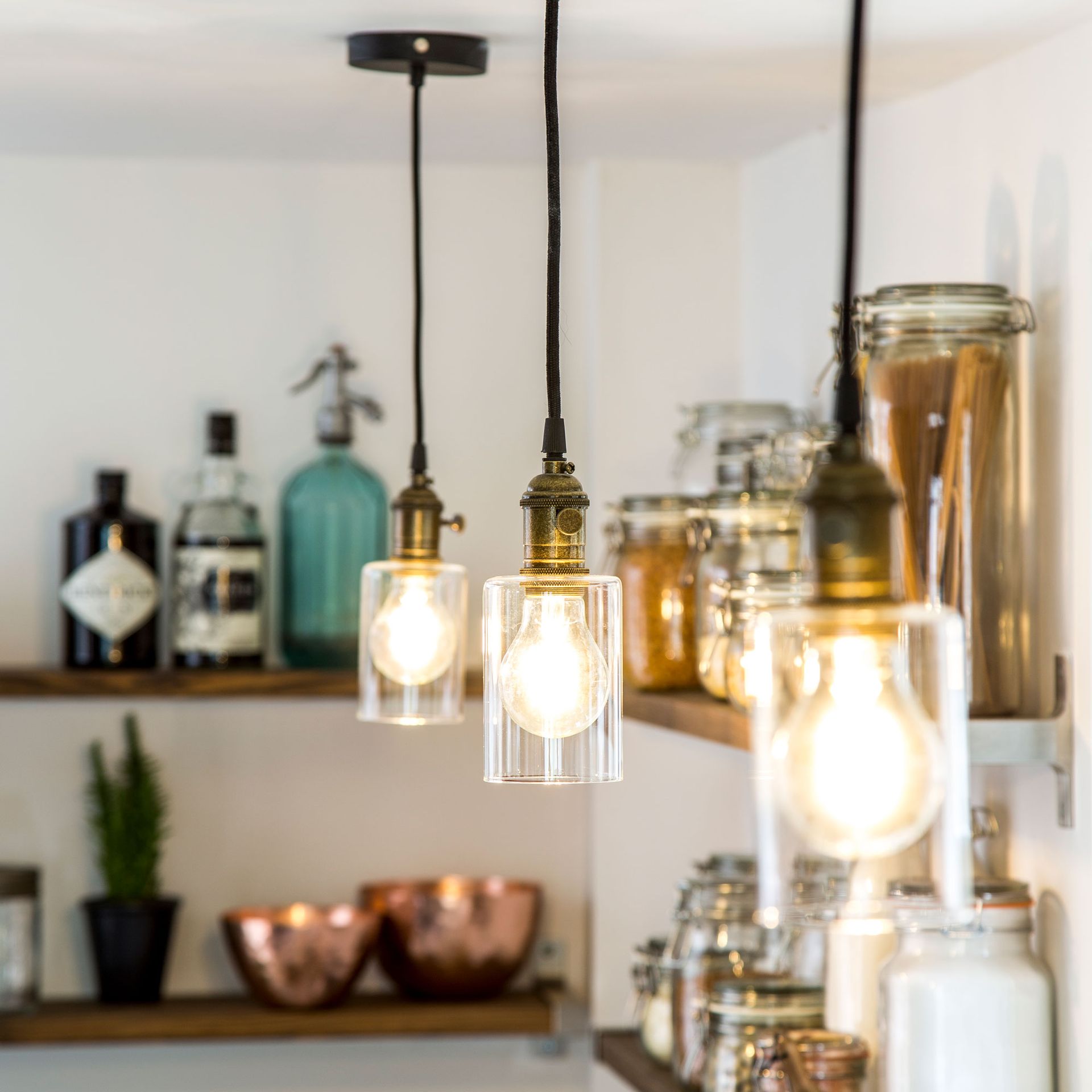kitchen with open shelving and three hanging exposed bulb lights