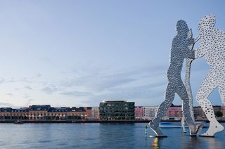 Large human form sculpture on river
