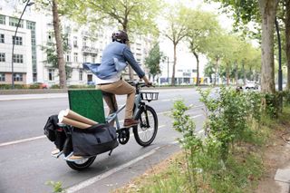 Image shows man riding the Elopes e-cargo bike with full load