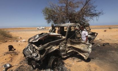 A man inspects a pro-Gadhafi vehicle bombed by NATO: While Libyan rebels were helped by NATO's air war, some say this will be the alliance's last military intervention.