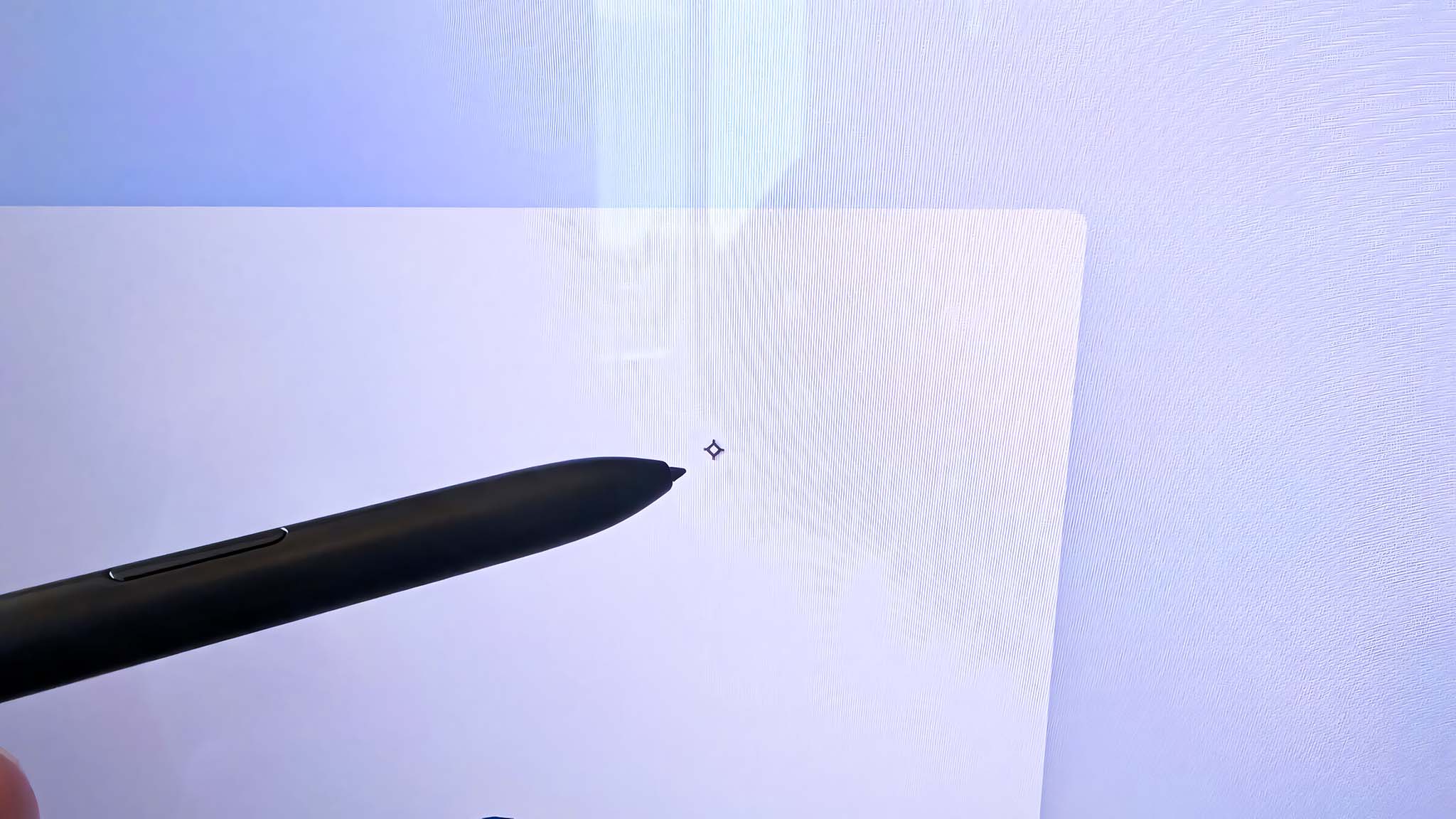 S Pen being held slightly away from the laptop screen and the cursor being detected on the display.