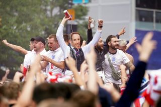 An England fan dressed as Gareth Southgate pours beer over his own head