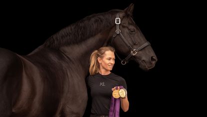 Lottie Fry stood at Glamourdale&rsquo;s shoulder holding medals, with a blacked out background