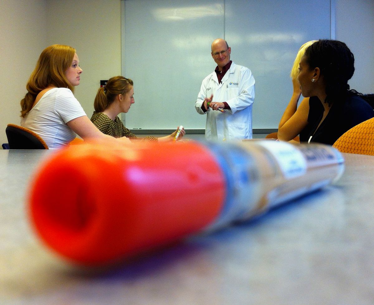 Daniel Scherzer, an emergency medicine physician at Nationwide Children’s Hospital, explains proper EpiPen use to a group of students.