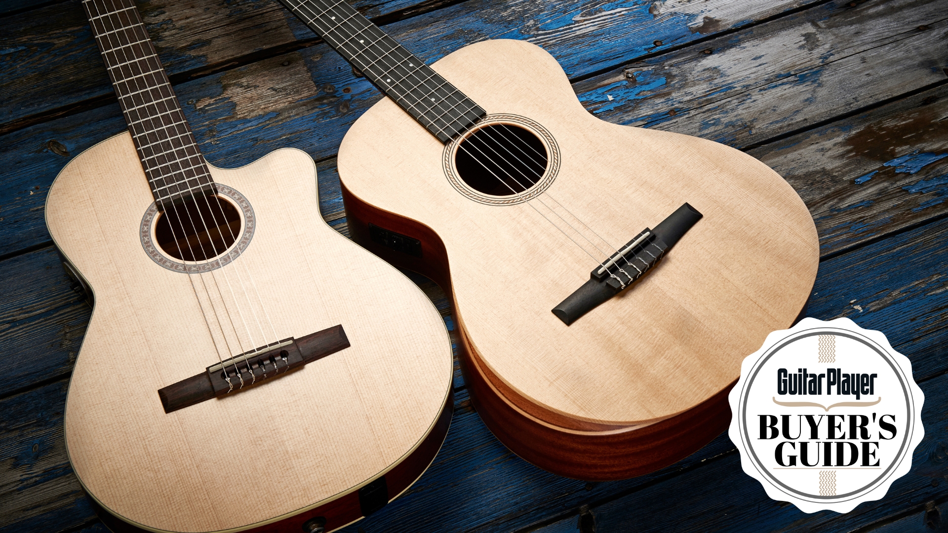 Two Taylor classical guitars lying on a distressed wooden floor