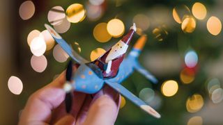 Hand holding Santa in a plane Christmas decoration